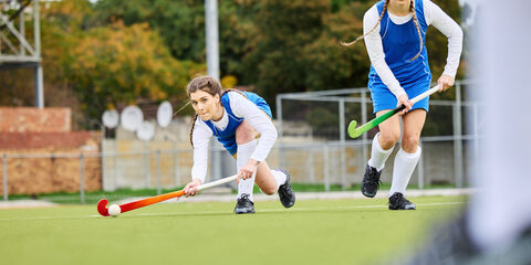 Fitness, workout and female hockey players training for a game, match or tournament on an outdoor field. Sports, exercise and young women playing at practice with a stick and ball on pitch at stadium.