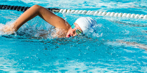 Close up action shot of Teen boy swimming freestyle at swimming lesson.