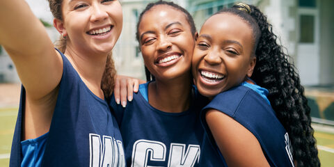 Sports, team and girl netball selfie, hug with fitness and college or school club with outdoor portrait. Exercise, competitive sport and happy people, smile in picture and player training on court